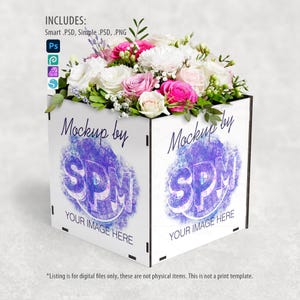 May include: A white square box mockup with a floral arrangement of pink, white, and green flowers. The box has the text "Mockup by SPM" and "YOUR IMAGE HERE" printed on it. The image includes the text "INCLUDES: Smart .PSD, Simple .PSD, .PNG".