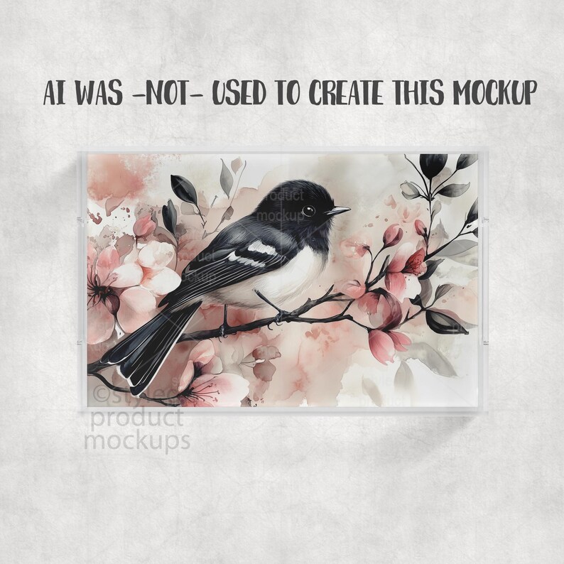 May include: A framed watercolor print featuring a black and white bird perched on a branch with pink blossoms. The artwork has a soft, muted color palette and is set against a neutral background. Text at the top reads "AI WAS -NOT- USED TO CREATE THIS MOCKUP".