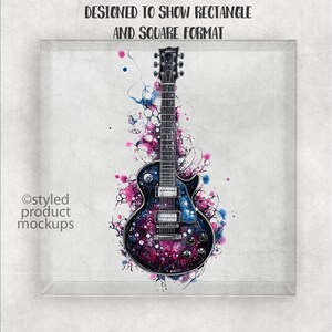 May include: A black electric guitar with a galaxy-like design and pink and blue watercolor splatters. The guitar is in a white frame with a gray background.