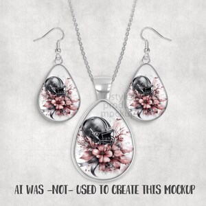 May include: A silver-toned jewelry set featuring a pendant necklace and matching earrings. Each piece has a teardrop shape with a football helmet design set against a floral background in shades of pink and gray. The text at the bottom reads "AI WAS -NOT- USED TO CREATE THIS MOCKUP."