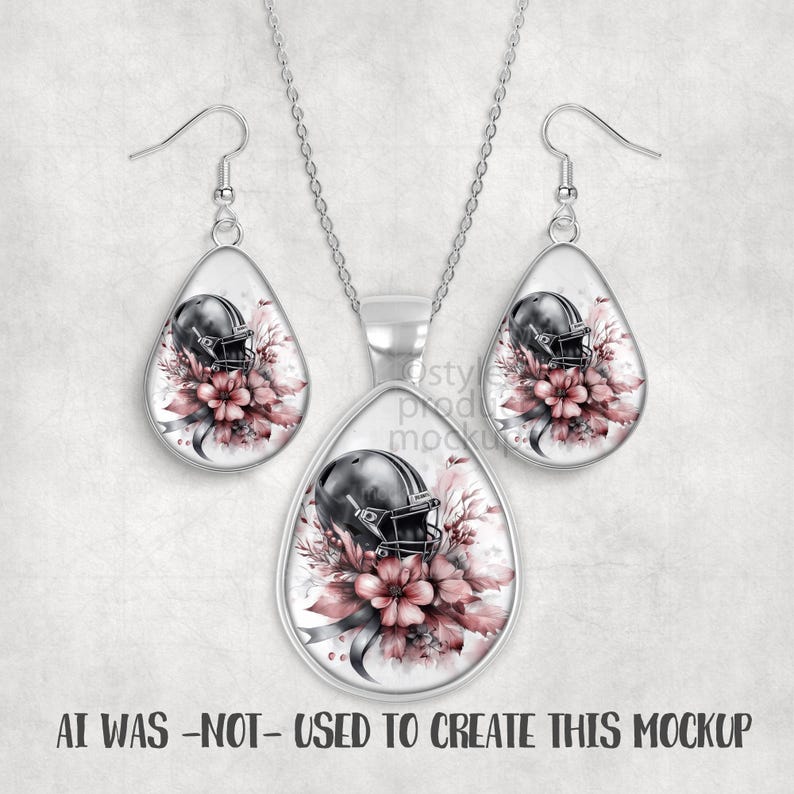 May include: A silver-toned jewelry set featuring a pendant necklace and matching earrings. Each piece has a teardrop shape with a football helmet design set against a floral background in shades of pink and gray. The text at the bottom reads "AI WAS -NOT- USED TO CREATE THIS MOCKUP."