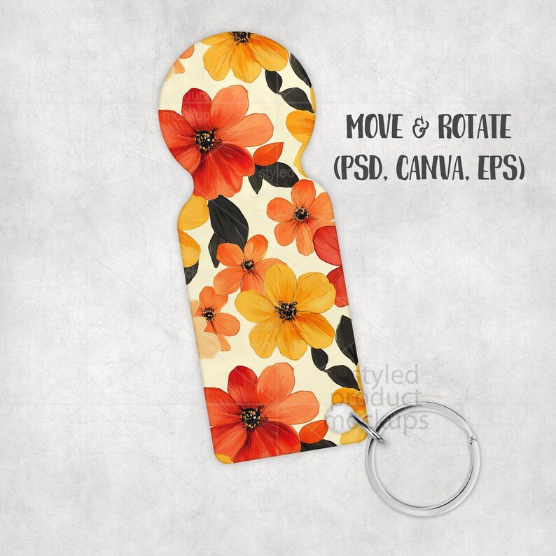 May include: A floral keychain with a cream background and a pattern of orange and yellow flowers with black leaves. The keychain has a silver metal ring and the text "MOVE & ROTATE (PSD, CANVA, EPS)".