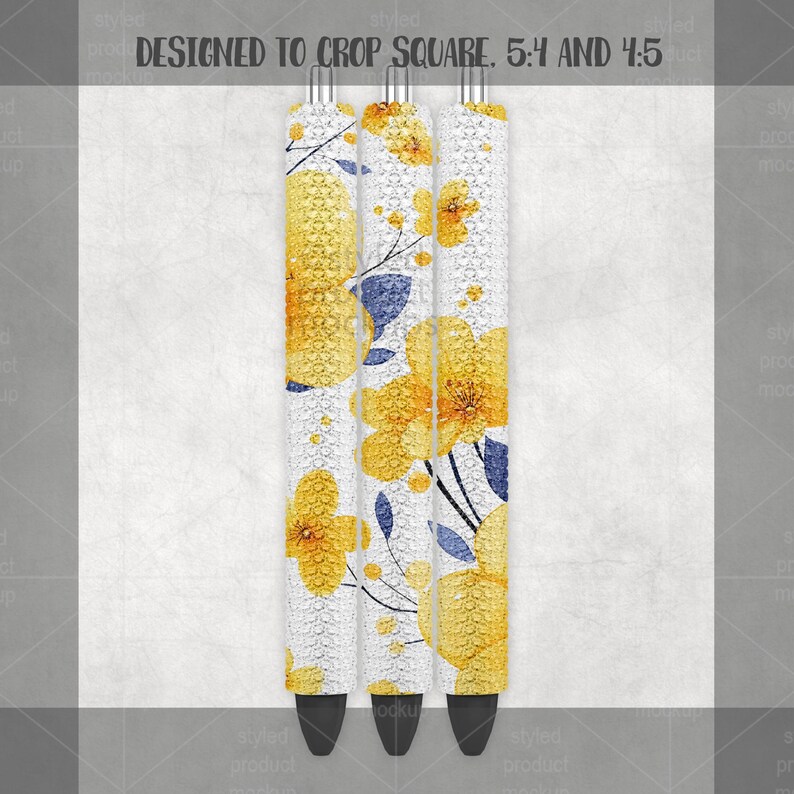 May include: Three pens with a floral design. The pens have a white background with yellow flowers and blue accents. The text "DESIGNED TO CROP SQUARE. 5:4 AND 4:5" is at the top.