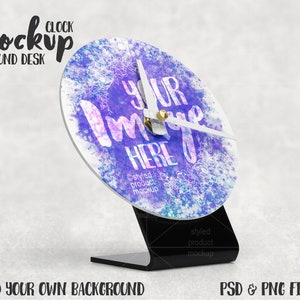 May include: A white round clock with a black stand. The clock face has a watercolor background with purple, pink, and blue hues. The clock hands are white and the text "Your Image Here" is printed on the clock face.