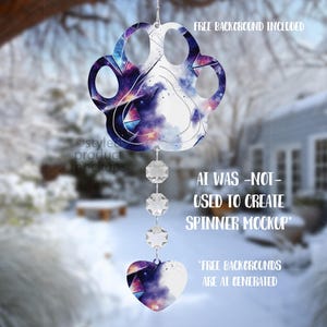 May include: A paw-shaped ornament with a galaxy design, suspended by crystal beads and a heart charm. The ornament features text: "FREE BACKGROUND INCLUDED" and "AI WAS -NOT- USED TO CREATE SPINNER MOCKUP".