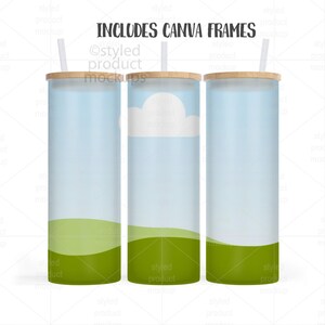May include: Three glass tumblers with bamboo lids and straws. The tumblers feature a sky and landscape design with a blue sky, white cloud, and green grass. The text "INCLUDES CANVA FRAMES" is at the top.