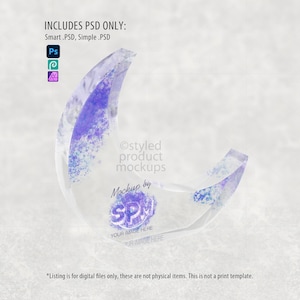 May include: A transparent crescent moon shape with purple and blue accents. The image includes text that reads "INCLUDES PSD ONLY: Smart .PSD, Simple .PSD" and "Ostyled product mockups". The image also includes the text "Mockup by SPM".