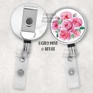 May include: A silver retractable badge holder with a white background and a pink watercolor floral design. The design features a bouquet of pink roses with green leaves. The text "EASILY MOVE & ROTATE" is printed in black below the design.