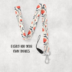 May include: A floral lanyard with a cream background, featuring red flowers and navy leaves. The lanyard has a black clasp and a silver metal clip. The text "EASILY ADD YOUR OWN IMAGES" is printed in black.