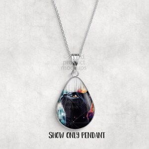May include: A silver pendant necklace featuring a teardrop-shaped pendant with a black cat design. The cat's face is visible, set against a colorful, cosmic background. The text "SHOW ONLY PENDANT" is at the bottom of the image.