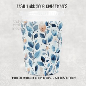 Puede incluir: Una taza de caf&eacute; blanca con tapa transparente y funda estampada. La funda presenta un dise&ntilde;o de acuarela de hojas azules y acentos color melocot&oacute;n sobre un fondo blanco. El texto en la parte superior dice "EASILY ADD YOUR OWN IMAGES".