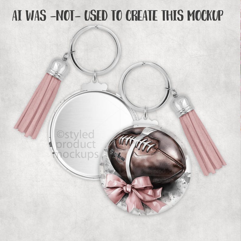 May include: Two keychains with silver rings and pink tassels. One keychain has a blank, round, silver pendant. The other keychain has a round pendant with a brown football design and a pink bow. The text "AI WAS -NOT- USED TO CREATE THIS MOCKUP" is at the top.