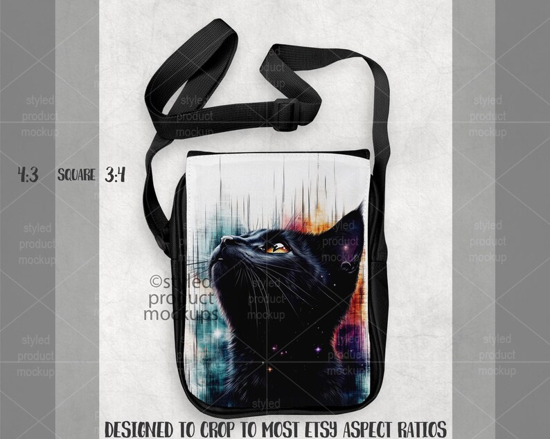 K&ouml;nnte beinhalten: Schwarze Umh&auml;ngetasche mit einem auff&auml;lligen Katzenportr&auml;t, gelben Augen und einem farbenfrohen kosmischen Hintergrund. Die Tasche hat einen schwarzen, verstellbaren Riemen und ist f&uuml;r die meisten Etsy-Seitenverh&auml;ltnisse konzipiert.