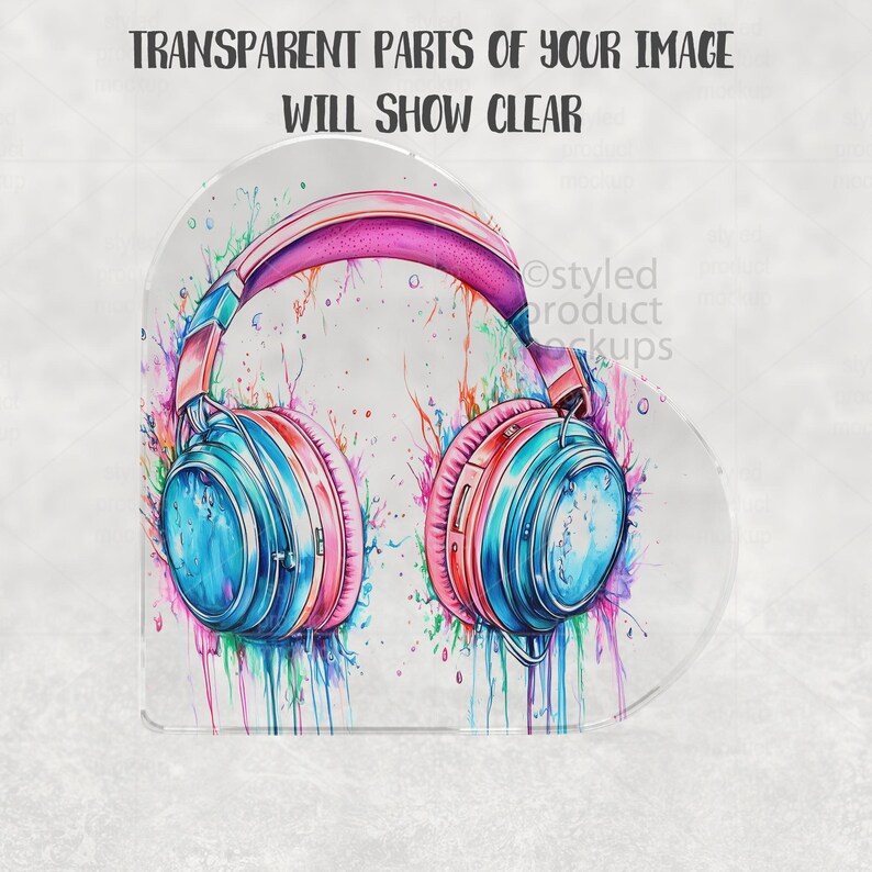 May include: A colorful watercolor design of headphones with a pink headband and earcups in shades of blue and red. The design includes paint splatters in various colors. The text "TRANSPARENT PARTS OF YOUR IMAGE WILL SHOW CLEAR" is at the top.
