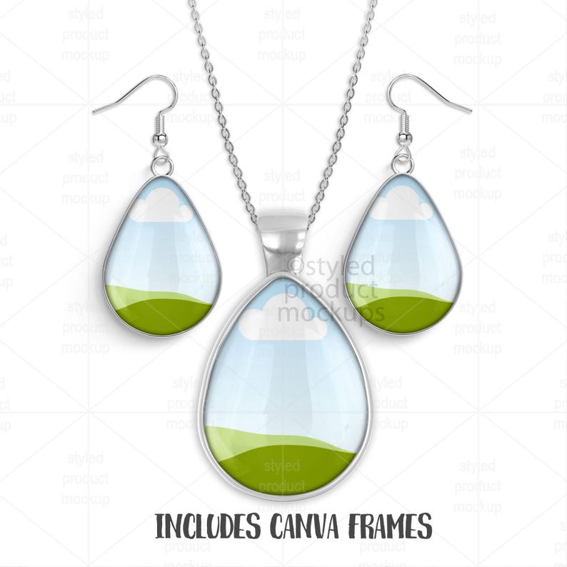 May include: A silver-toned necklace and earring set. The pendant and earrings are teardrop-shaped with a landscape design featuring a blue sky, white clouds, and green hills. The text "INCLUDES CANVA FRAMES" is at the bottom.