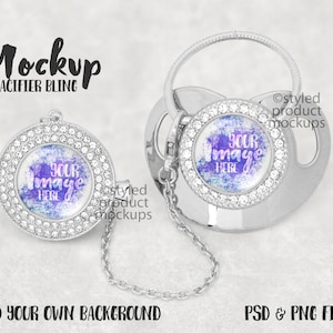 May include: Silver pacifier clip with a clear round charm that has a sparkly purple and blue design and the text "YOUR IMAGE HERE".