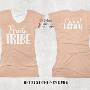 Op de afbeelding: Twee perzikkleurige T-shirts met witte tekst. Het voorste shirt zegt "Bride Tribe" en het achterste shirt zegt "Maid of Honor".