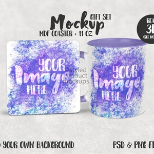 Op de afbeelding: Een mockup van een cadeauset met een witte keramische mok en een vierkante onderzetter. Beide items hebben een aquarelontwerp in paarse, blauwe en roze tinten. De tekst "Your Image Here" is gedrukt op zowel de mok als de onderzetter. De mok heeft een paarse deksel. De tekst "Real 3D (See Notes)" staat in een cirkel in de rechterbovenhoek van de afbeelding. De tekst "Mockup Gift Set MDF Coaster + 11 oz" staat in het midden bovenaan de afbeelding.