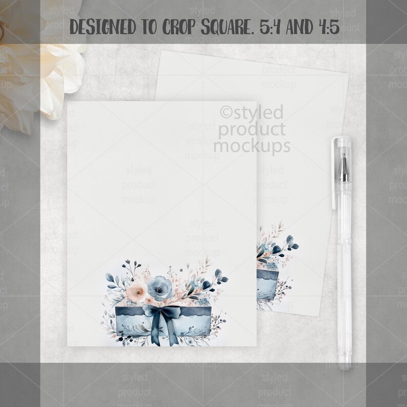 Puede incluir: Una maqueta con dos tarjetas blancas y un sobre, adornada con un dise&ntilde;o floral en acuarela en tonos azules y melocot&oacute;n. Un bol&iacute;grafo transparente est&aacute; a la derecha. El texto "DESIGNED TO CROP SQUARE. 5:4 AND 4:5" est&aacute; arriba.