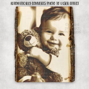 Op de afbeelding: Een sepia-getinte houten plaat met een laserge&euml;tste afbeelding van een lachende baby die een teddybeer vasthoudt. De plaat heeft een natuurlijke schorsrand en de tekst "AUTOMATICALLY CONVERTS PHOTO TO LASER EFFECT" bovenaan.