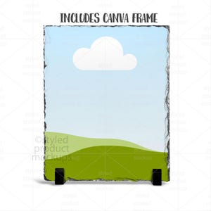 Puede incluir: Un panel fotogr&aacute;fico rectangular de pizarra con un dise&ntilde;o de paisaje, sostenido por dos soportes negros. La imagen presenta un cielo azul con una nube blanca y colinas verdes. El texto "INCLUDES CANVA FRAME" est&aacute; en la parte superior.