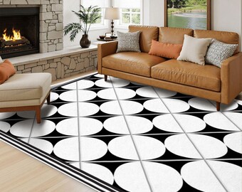 May include: A large area rug featuring a repeating geometric pattern of white circles set against a black background, accented by thin white grid lines and a triple-striped border along the edge, covering the floor in a living room setting.