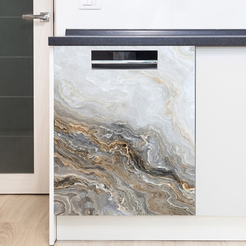 May include: A dishwasher with a decorative front panel featuring a marble-like design. The panel has a swirling pattern of gray, white, and gold tones, creating a natural stone appearance. The dishwasher is integrated into a white kitchen cabinet.