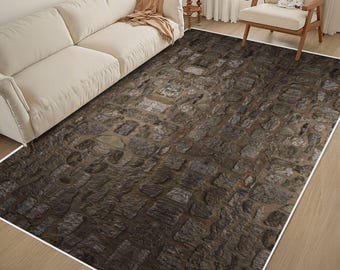 May include: A rectangular area rug featuring a high-resolution photographic print of a dark brown and gray cobblestone path. The rug displays a repeating pattern of irregular, weathered stones with deep grout lines, creating a textured appearance.
