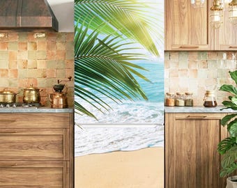 May include: A tall, rectangular refrigerator featuring a full-length photographic wrap of a tropical beach scene. The image displays bright green palm fronds hanging over turquoise ocean waves crashing onto a light tan sandy shore.