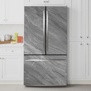 May include: A contemporary fridge freezer with a grey marble-effect finish. It features two doors and a bottom freezer drawer. The doors have vertical stainless steel handles. The overall design is sleek.