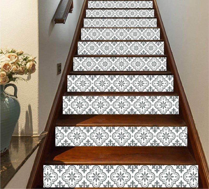 May include: Wooden staircase with decorative stair treads featuring a gray and white floral pattern. The treads are applied to the front of each step, creating a stylish and patterned design element in the home.