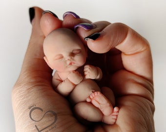 Bébé Simon(e) endormi miniature en silicone solide 5,7 cm (2,24") avec les jambes pliées
