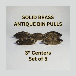 Pode incluir: Cinco puxadores de gaveta antigos em latão maciço com detalhes ornamentados. Os puxadores têm 7,6 cm entre os centros. O texto na imagem diz "SOLID BRASS ANTIQUE BIN PULLS 3" Centers Set of 5."