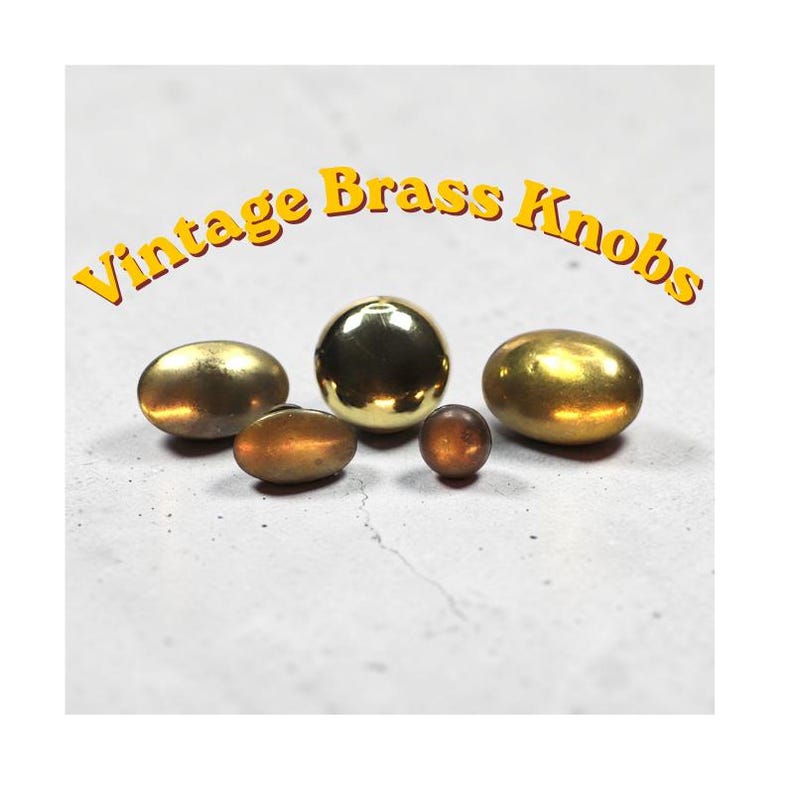 Mixed set of vintage solid brass cabinet knobs in various sizes and patina finishes ranging from polished gold to aged brass displayed on neutral background