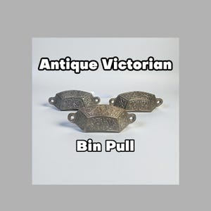 Op de afbeelding: Drie antieke Victoriaanse baktrekkers met sierlijke bloemmotieven. De trekkers zijn gemaakt van een zilverkleurig metaal en hebben een rechthoekige vorm met afgeronde randen. De tekst "Antique Victorian" en "Bin Pull" wordt weergegeven.