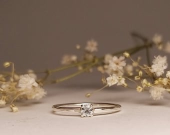 narrow engagement ring in silver with aquamarine in a 4-prong setting