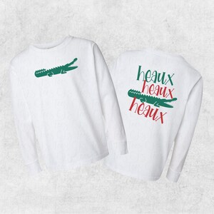 May include: White long-sleeve shirt with a green alligator on the front and the text "heaux heaux heaux" in red on the back.