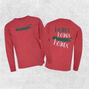 May include: Red long-sleeve t-shirt with a green alligator graphic on the front and the text "heaux heaux heaux" on the back.