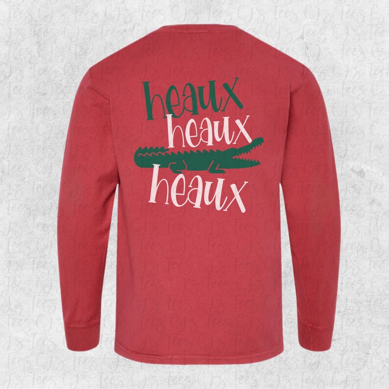 May include: Red long-sleeve t-shirt with a green alligator and the text "Heaux Heaux Heaux" printed on the back.