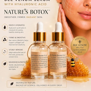 May include: Two clear glass dropper bottles of B Venom Bee Venom Serum with Hyaluronic Acid, each labeled 10 ml. The bottles feature gold caps and are positioned in front of a honeycomb structure with a small bee charm attached to the twine.