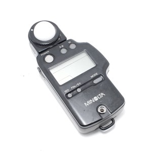 以下が含まれることがあります： 白いドーム、デジタルディスプレイ、電源、ISO、Fn/EV、モードボタンが付いた黒いミノルタ露出計