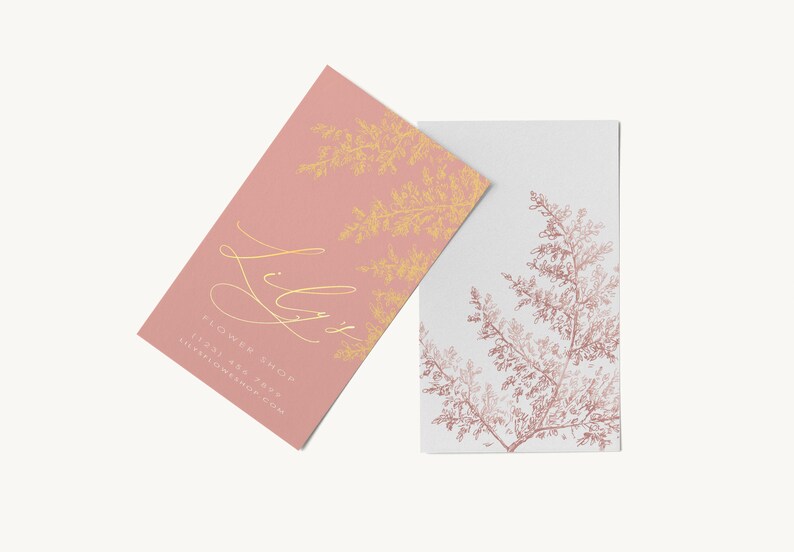May include: Two business cards with a floral design. The top card is pink with gold lettering that says "Lily's Flower Shop" and a gold floral design. The bottom card is white with a pink floral design.