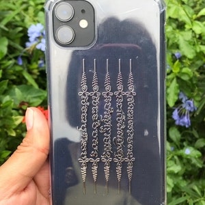 May include: A clear phone case with a black background and silver lettering. The lettering is in a traditional Thai script.