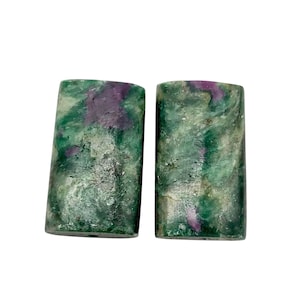 May include: Two rectangular gemstones with a marbled appearance. The stones are primarily green with streaks of purple and white. The gemstones have a polished, smooth surface and are set against a white background.