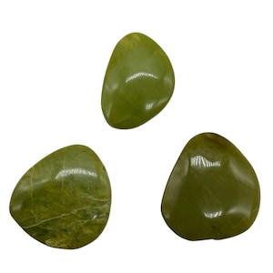 May include: Three polished, olive-green gemstones with smooth, rounded shapes. The stones have a glossy finish and varying shades of green, with some showing subtle veining. The gemstones are set against a white background.