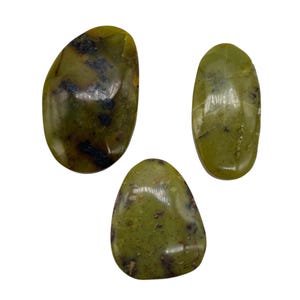 May include: Three polished green stones with dark inclusions. The stones have smooth, rounded shapes and a glossy finish. The color is a muted olive green with darker green and black markings.