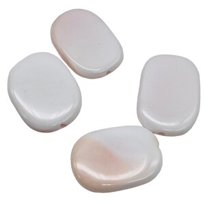 May include: Four smooth, oval-shaped beads in shades of white and pale pink. Each bead has a small hole, suggesting they are designed for stringing. The beads have a glossy, polished finish, reflecting light.