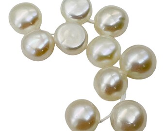 May include: A close-up shot of a string of creamy, off-white pearls. The pearls are mostly round with a soft sheen, connected by a fine, white thread. The pearls' slight variations in size and form give them a natural, sophisticated appearance.