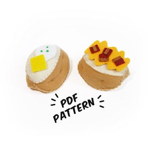 May include: Two felt food items, a potato with butter and chives and a potato with bacon bits, both with a white base and brown felt for the potato. The text "PDF PATTERN" is written below the food items.