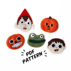 May include: A set of five felt character ornaments featuring a green frog, two orange pumpkins, a brown-haired boy, and a red-hatted boy. The ornaments are strung together with white thread and the text "PDF PATTERN" is written below them.